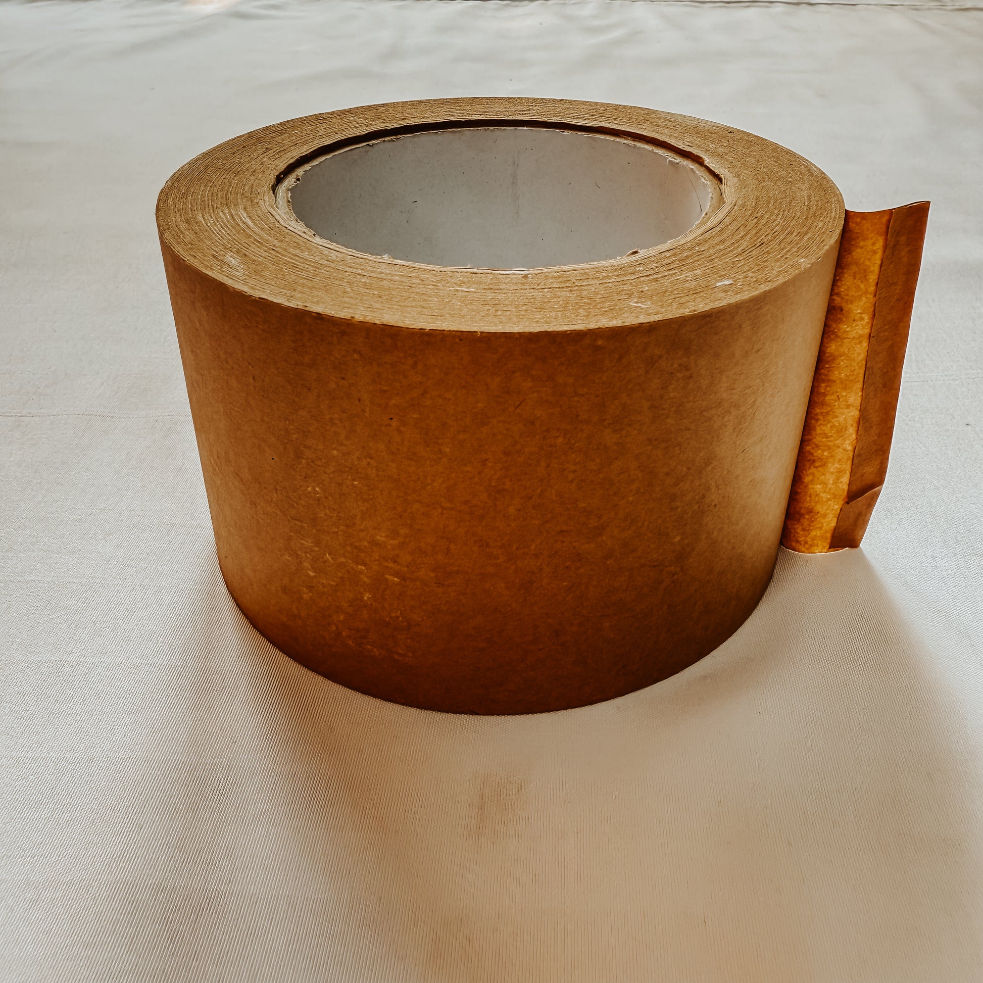 Tilted view of Jaivik Store EcoWrap Brown Kraft Paper Tape, 50m, Self-Adhesive – Eco-friendly, sustainable packaging choice