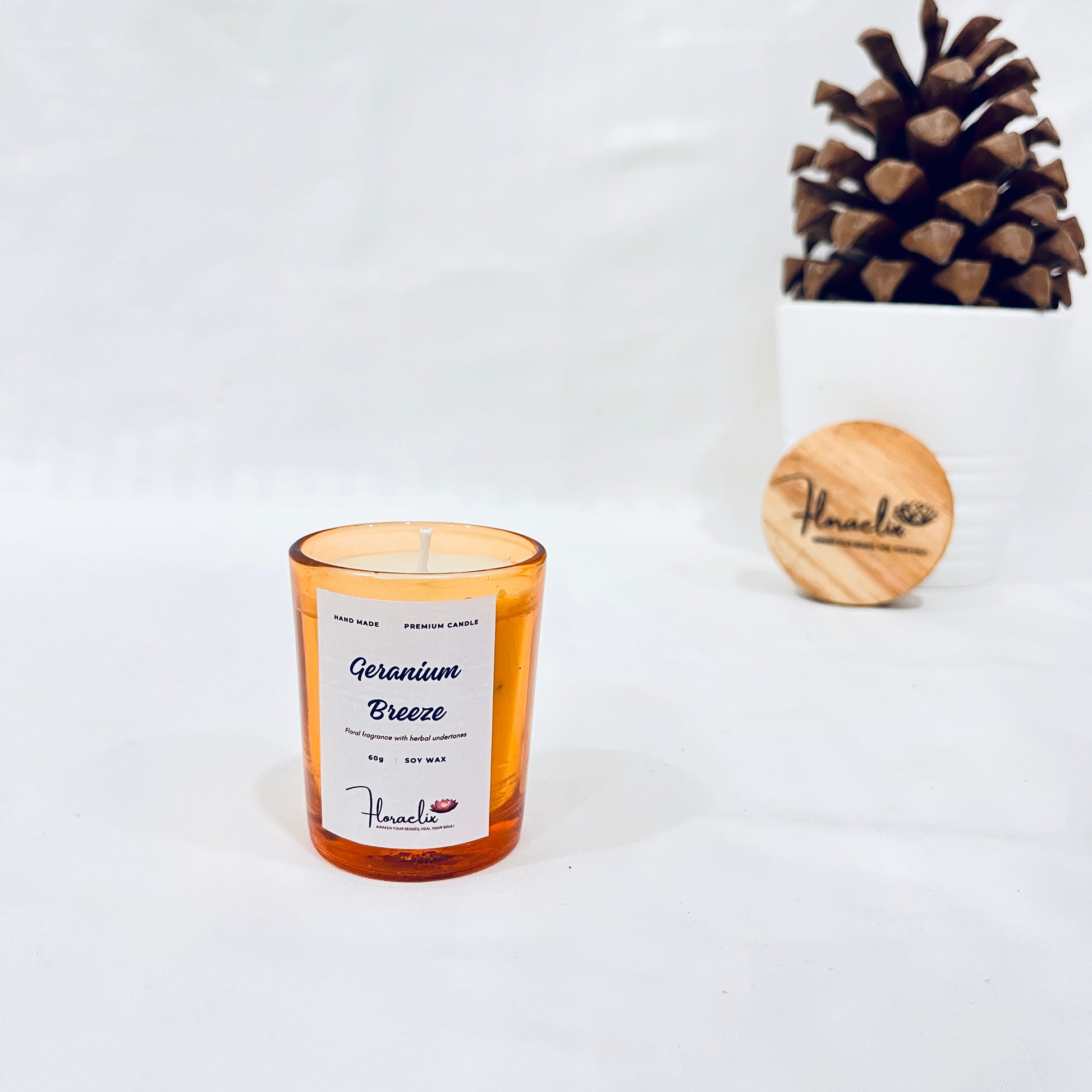 Jaivik Store Soothing Geranium Breeze soy wax candle, 60g, in a serene pine fruit backdrop, perfect for relaxation