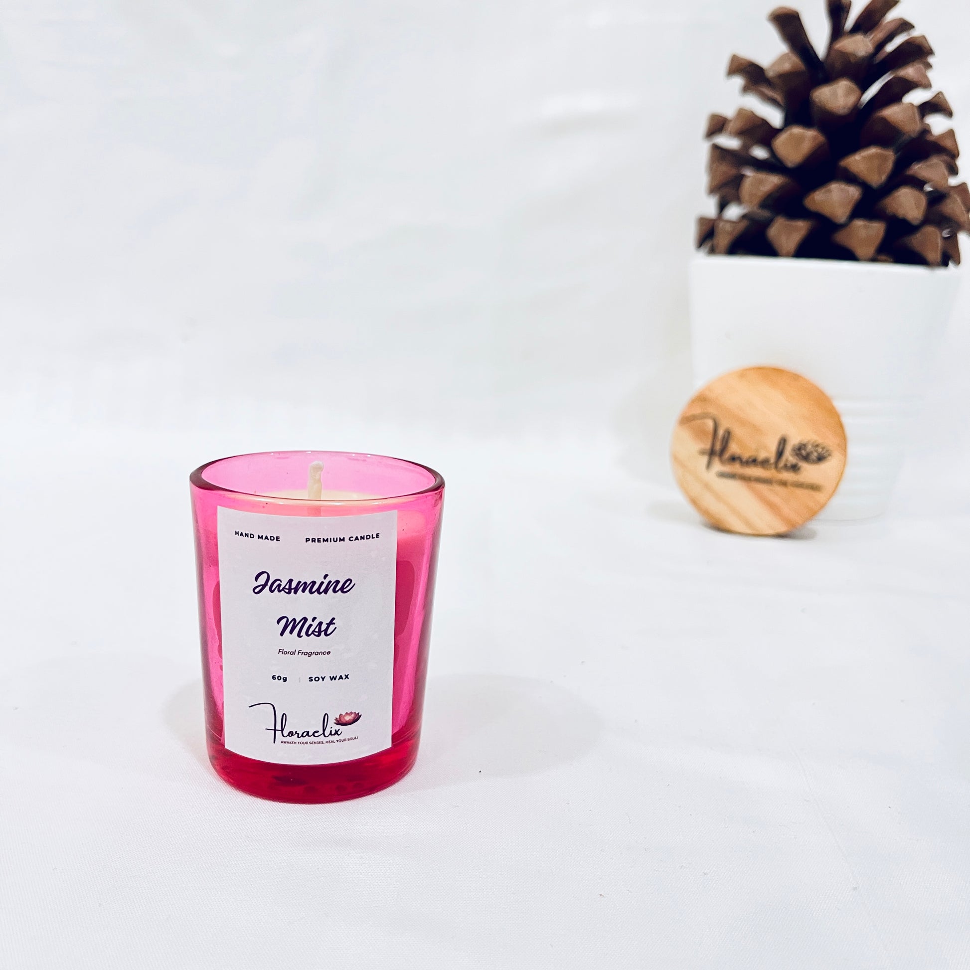 Jaivik Store Jasmine Mist soy wax candle, 60g, presented with a calming pine fruit backdrop, perfect for relaxation