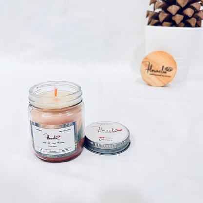 Jaivik Store Joy of the Wood soy wax candle, 100g, lid open, set against a pine fruit backdrop for a natural touch